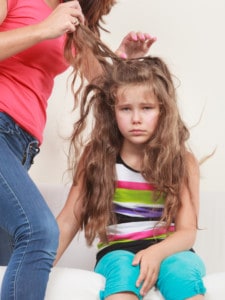Little girl getting her super lice combed out by her mother