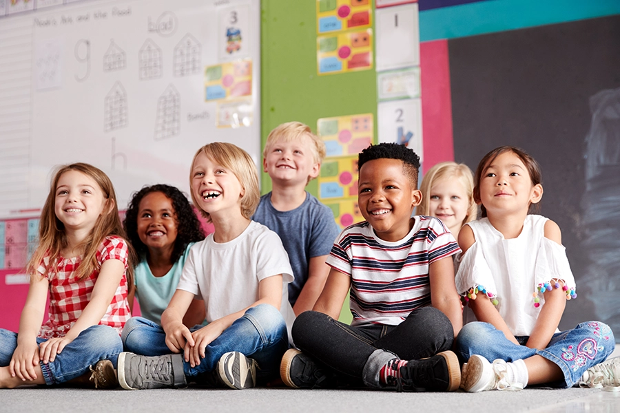 diverse group of children in school, sitting very close together on the floor - St. Charles, MO