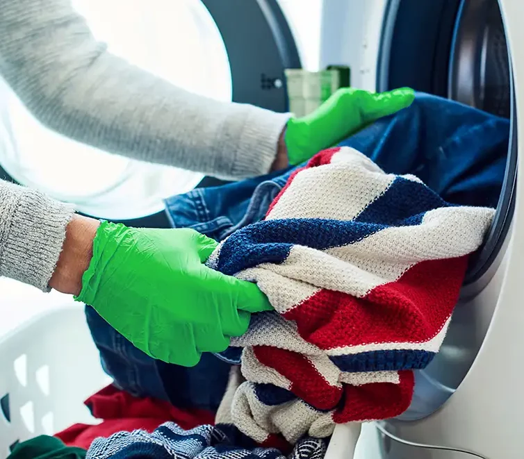 Cleaning after a case of head lice - mother is washing clothes to ensure no lice have survived treatment - St. Charles, MO