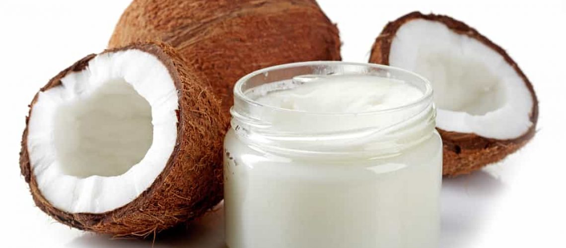 jar of coconut oil and fresh coconuts isolated on white