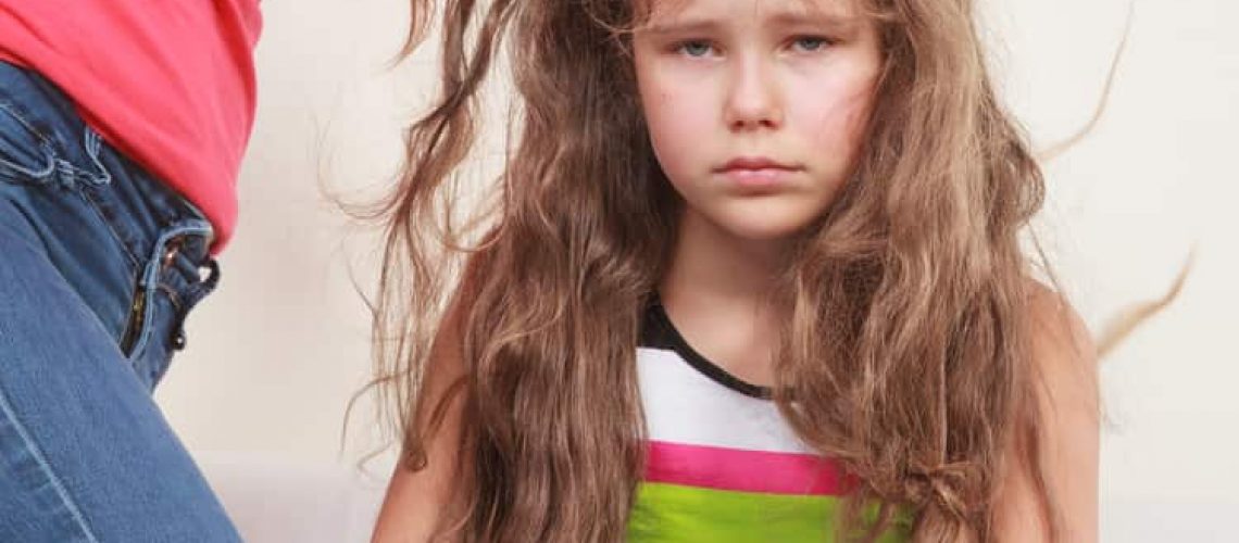 Little girl getting her super lice combed out by her mother